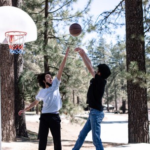 Two people playing basketball.