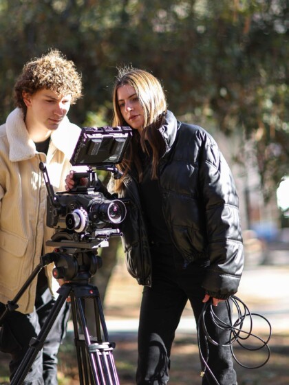 Two students filming outdoors.